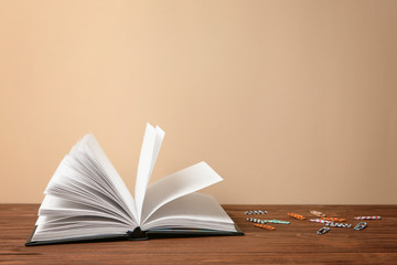 Notebook and paperclips on table against light background. Doing homework