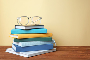 Books and glasses on table against light background. Doing homework