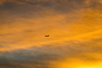 Commercial airplane flying at sunset sky