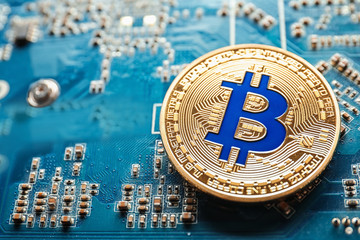Golden bitcoin on circuit board