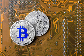 Silver bitcoins on circuit board