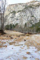 Landscape of Ice Forming on Banks of River with Forest and Mountains