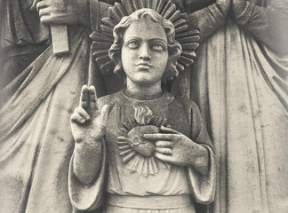 Detail of Holy Family. Young Jesus with sacred heart. Statue depicting Holy Family with child Jesus Christ.