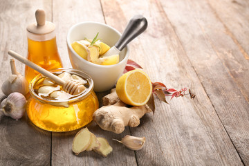 Composition with honey and garlic as natural cold remedies on wooden background