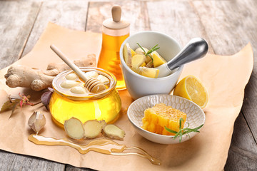 Composition with honey and garlic as natural cold remedies on wooden background