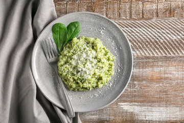 Plate with tasty spinach risotto on table, top view