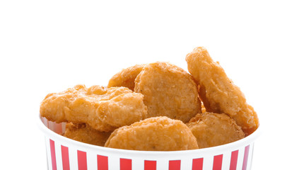 Paper cup with tasty chicken nuggets on white background