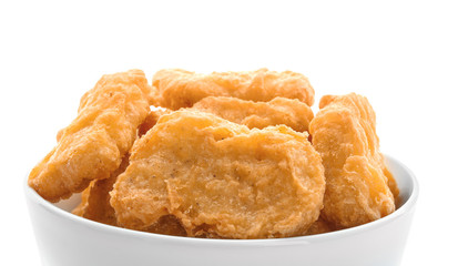 Ceramic bowl with tasty chicken nuggets on white background