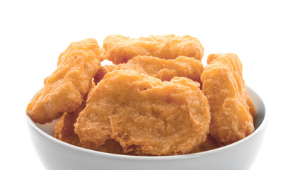 Ceramic bowl with tasty chicken nuggets on white background