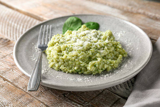 Plate with tasty spinach risotto on table, closeup