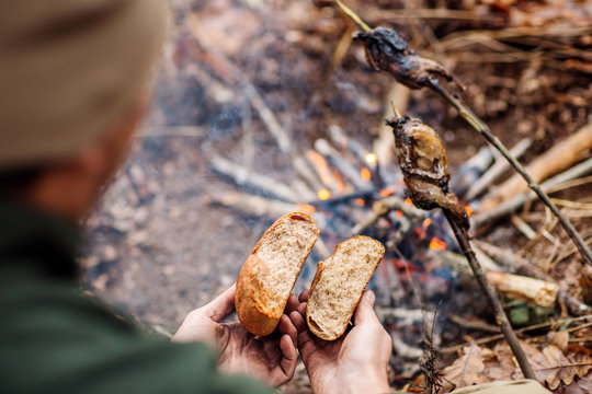 Hands of a hunter breaking and frying bread. bushcraft concept