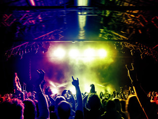 Concert people dancing in colorful stage lights