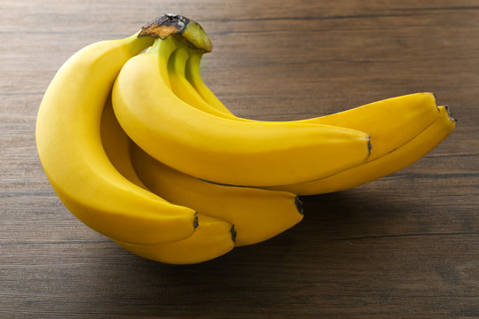 Ripe bananas on wooden background