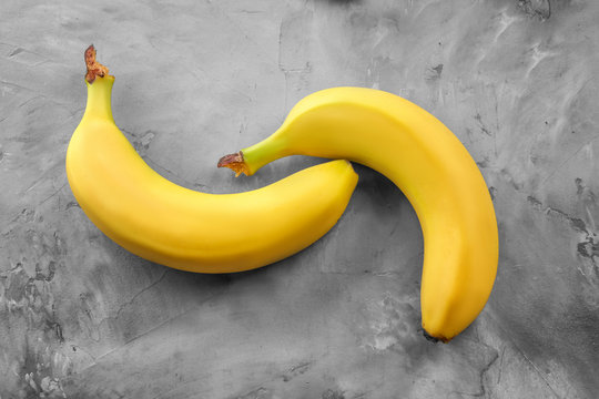 Ripe bananas on grey textured background