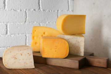 Different kinds of delicious cheese on table