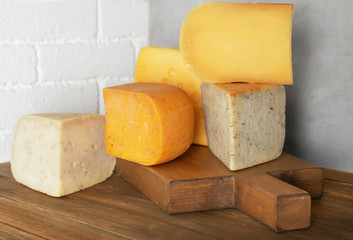 Different kinds of delicious cheese on table