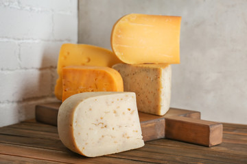 Different kinds of delicious cheese on table
