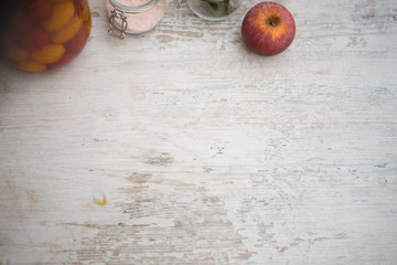 Fruits, glass jars, leaves and spices on a rustic white wooden table. Concept of healthy, natural food. Copy space for text.