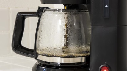 Coffee maker pot filling close up time lapse.