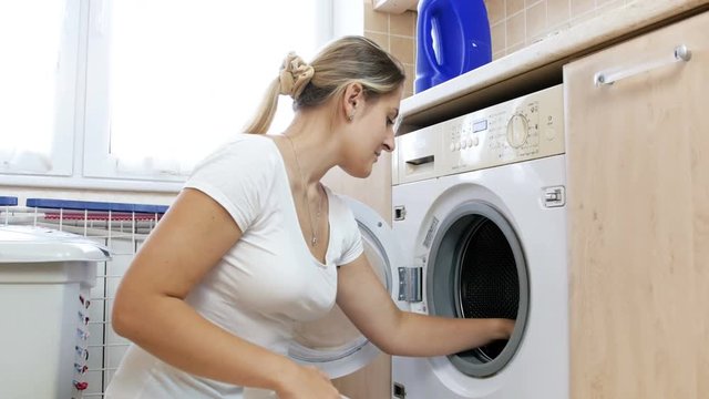 4k video of young woman made mistake by putting together different color clothes in washing machine