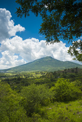 Summer landscape with mountains, cloudy sky, green grass and trees in Guatemala.