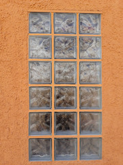 The glass block window on the orange wall