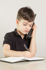 Young boy on the phone, making notes