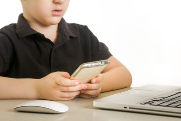 Young boy on the phone, in front of laptop
