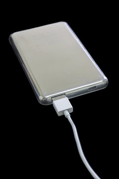 Portable power bank for charging mobile devices, isolated on black background
