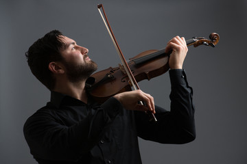 Musician man playing the violin. Musical instrument on performer hands. Classic music concept.