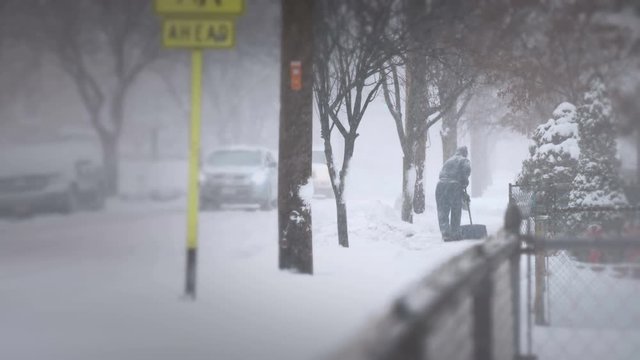 Unrecognizable man shoveling snow in the distance