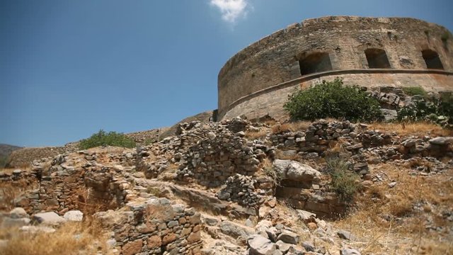 Ruins of an ancient fortress on the island of Spinalonga against the background of the sky. Cretan island of Spinalonga, location of the last leper colony in the whole of Europe. Crete. Greece