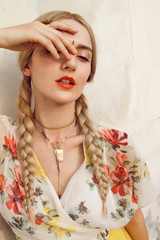 Close-up portrait of a beautiful young woman with a gorgeous bindi on her forehead. Long blonde hair is tangled in wonderful hairstyle. And she is dressed in a pretty dress.