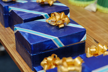Set of Blue with gold bow on gift box for present in celebrate event on wooden table. select focus at center of image