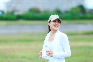 Fototapeta premium ペットボトルの水を持っている女性 ランニング