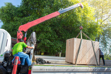 Mobile crane is unloading reinforcing mesh from truck trailer