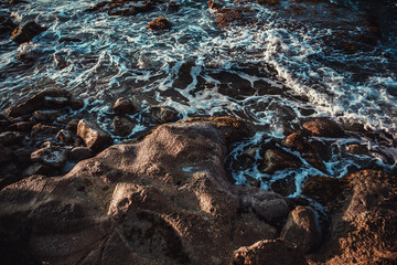 Foamy waves at rocky beach