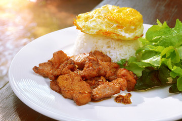 Fried gralic pork served with jasmine rice, fry egg and fresh vegetables salad.