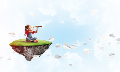 Concept of careless happy childhood with girl looking in spyglass