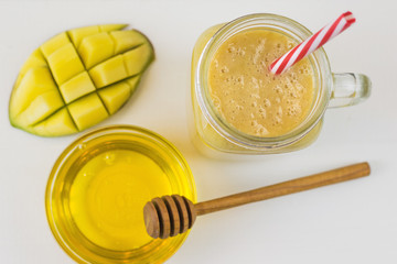 Freshly made smoothies with mango, banana, orange and cereal on a white wooden table. The view from the top.
