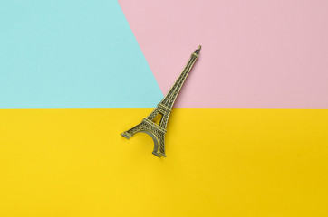 Souvenir statuette of the Eiffel Tower on a multicolored pastel background. Trend of minimalism.