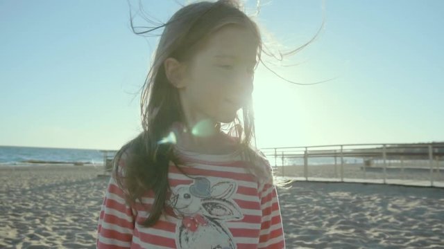 Little cute girl laughs and runs along beach