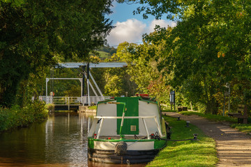 Fototapeta na wymiar The Monmouthshire & Brecon Canal with a boat and the lift bridge, seen in Talybont on Usk, Powys, Wales, UK