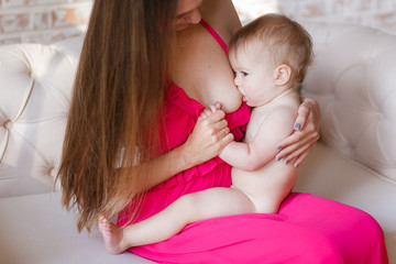 Mother feeding her baby. Sitting on the lap