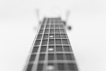 Abstract view of neck a wooden acoustic guitar closeup with soft focus. Black and white photo
