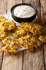 rispy Onion Bhajis vegan snack or starter with yogurt close-up. Vertical