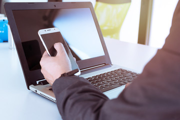 Business man, technology and internet concept, Close up of male hands with smartphone. Online shopping or banking concept, credit ,debit. Businessman using smart phone with conputer laptop on desk.