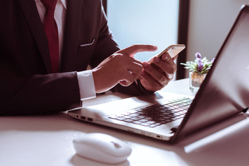 Business man, technology and internet concept, Close up of male hands with smartphone. Online shopping or banking concept, credit ,debit. Businessman using smart phone with conputer laptop on desk.
