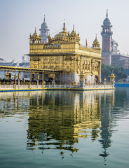 Fototapeta na wymiar Golden Temple, Sikh Gudwara in Amritsar, India. .Reflections on sacred pond of Harmandir Sahib, holiest shrine of the Sikh religion. Famous Indian landmark on sunny day.