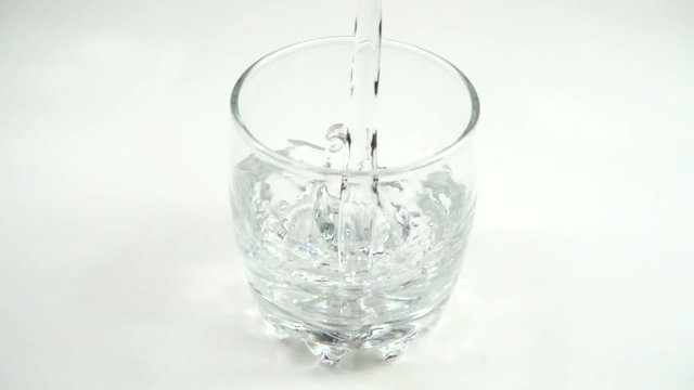 	Water is poured in a glass. Slow motion.